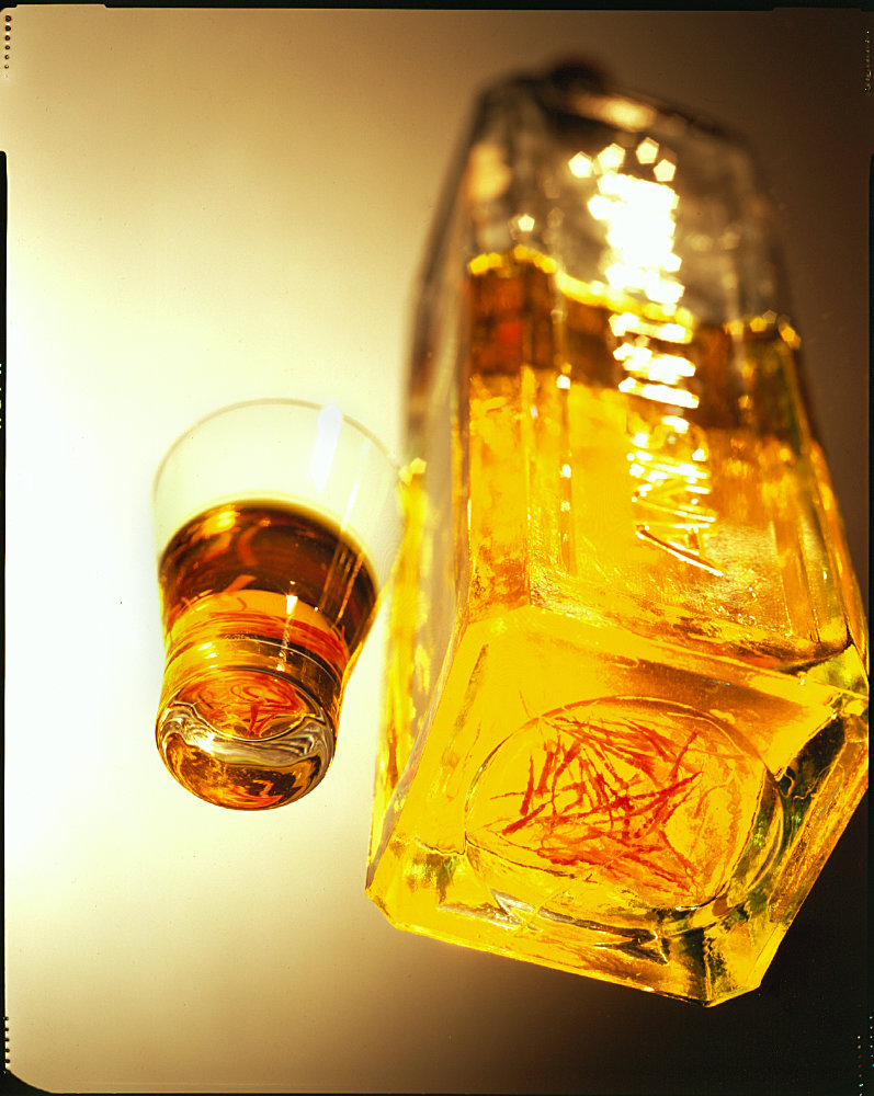 Whiskey bottle and shot glass – Photograph by George Ong