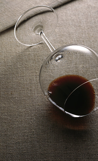 Glass of red wine on its side – Photograph by George Ong