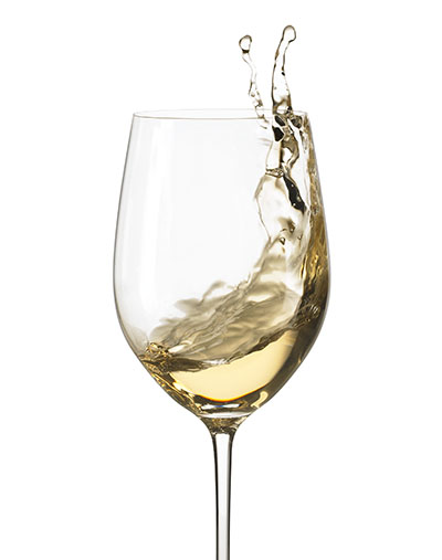 Action shot of white wine swirled in wine glass – Photograph by George Ong