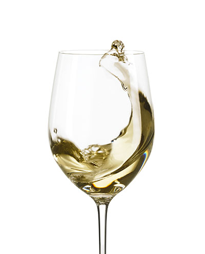 Action shot of white wine swirled in wine glass – Photograph by George Ong